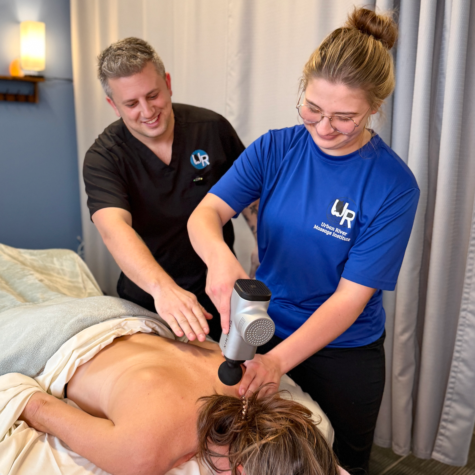 Urban River massage therapy instructor teaching techniques to a student